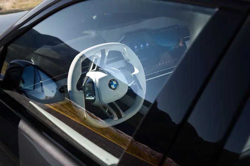 BMW 320 · 디테일. 창 너머로 보이는 밝은 색상의 스티어링 휠.